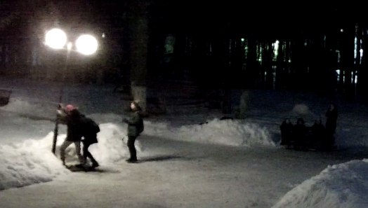 Школьники разбивают фонарь в парке.